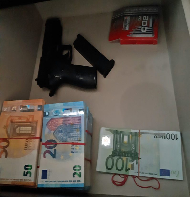 Poliisin kuva kotietsinnältä epäillyn asunnosta, käteistä rahaa ja muovikuula-ase.