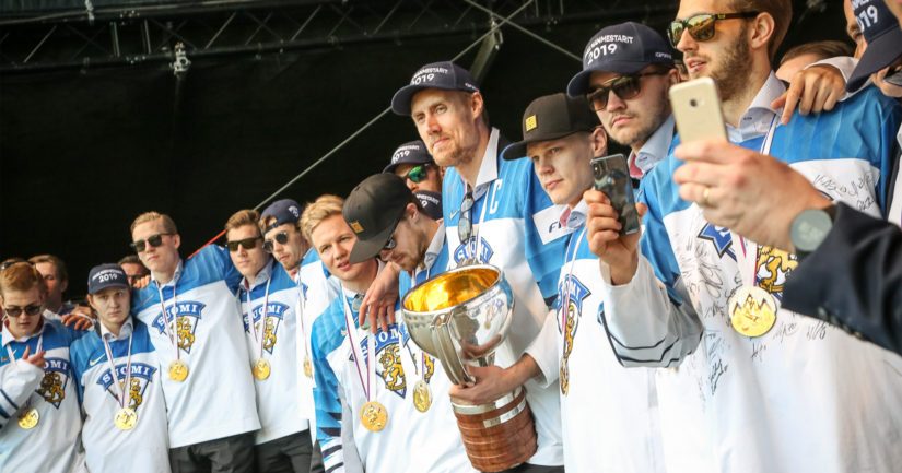 Leijonat kuuntelevat presidentin puhetta, mestaruuspokaali kapteeni Marko Anttilan hallussa.