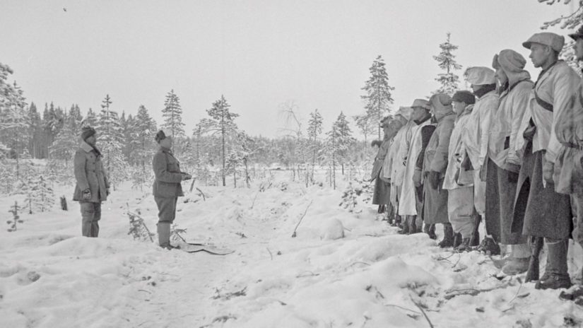 Joukkojen edessä Aarne "Marokon Kauhu" Juutilainen sekä joulujumalanpalvelusta Kollaalla 1939 pitävä pastori Antti Rantamaa.