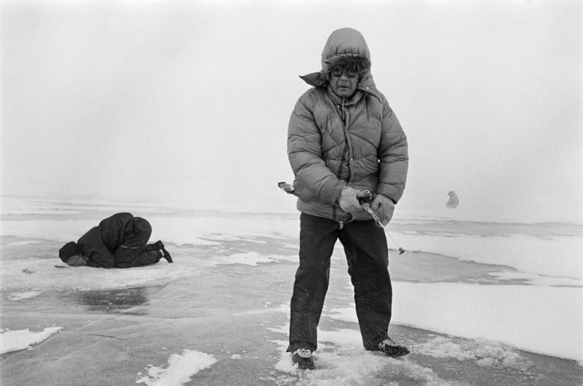 Kekkonen pilkillä Somaslompolossa Käsivarren Lapissa 19.4.1970, rajamies tähystää jään läpi saalista.